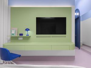 a living room with a tv and a blue chair at Lesi City Guide Hotel in Kyiv