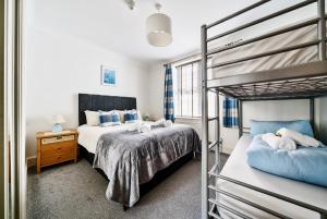a bedroom with two beds and a bunk bed at Southover Beach in Woolacombe