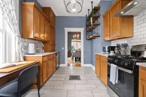 a kitchen with wooden cabinets and a stove top oven at Riverview Escape in Walkable Historic District in Jeffersonville
