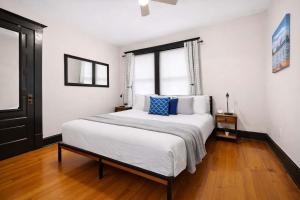 a bedroom with a large white bed with blue pillows at Riverview Escape in Walkable Historic District in Jeffersonville