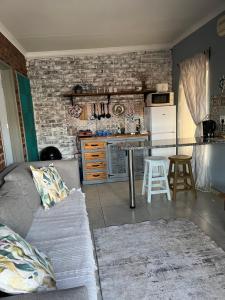a living room with a couch and a kitchen at Cottage 49 in Parys