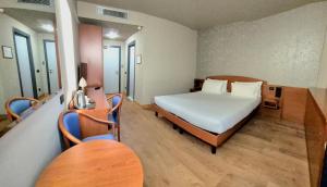 a bedroom with a bed and a table and chairs at Hotel Le Cerbaie in Altopascio