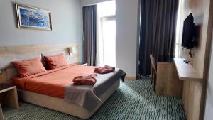 a hotel room with a bed and a television at Naftalan Central Wellness Resort in Naftalan