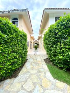 a stone walkway in front of a house with bushes at Privat 3 bedroom apartment in Sosua