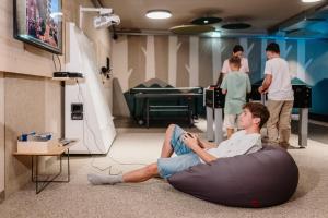 a man laying on the floor in a room with people at Hotel Adler in Au im Bregenzerwald