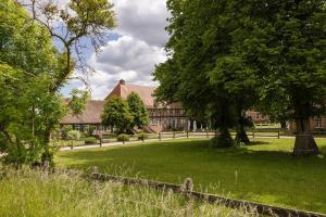 a large building with a green yard with trees at Pförtnerhaus in Gartow