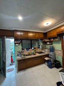 a large kitchen with wooden cabinets and a large counter at Odara Pines Garden The Ridge House 1BR in Baguio