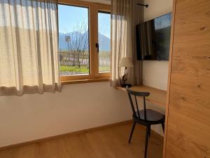 a room with a desk with a chair and a window at Alm Annerl - Neue Ferienwohnungen in Obermaiselstein in Obermaiselstein