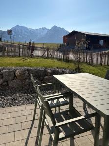 a picnic table and a chair next to a fence at Alm Annerl - Neue Ferienwohnungen in Obermaiselstein in Obermaiselstein