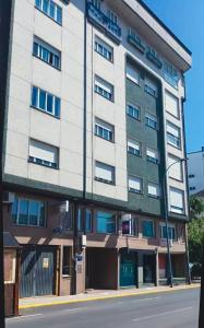 a tall white building on the side of a street at Tu piso en el Camino de Santiago in Sarria
