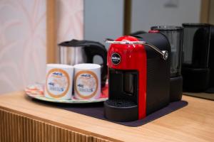 a red coffee maker sitting on a counter with two cups at 5 Terre Lodge in La Spezia