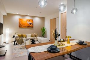 a kitchen and living room with a table and a couch at AoiResidence別邸葵 in Nagoya