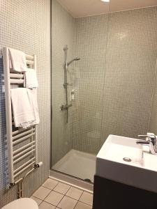 a bathroom with a shower and a toilet and a sink at The Originals Boutique, Hôtel Ô Gayot, Bagnoles-de-l'Orne in Bagnoles de l'Orne