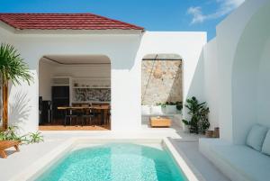 a villa with a swimming pool in front of a house at Villa Charlotte in Selong Belanak