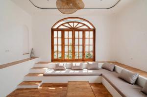 a living room with a large couch and a window at Villa Charlotte in Selong Belanak +23 photos
