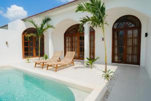 a villa with a swimming pool and two chairs at Villa Charlotte in Selong Belanak