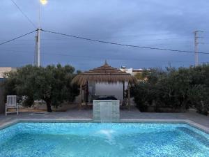 a swimming pool with a gazebo and a swimming pool at Djerba 7 in Aghīr