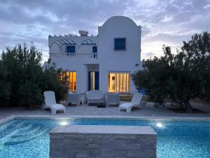 a villa with a swimming pool in front of a house at Djerba 7 in Aghīr