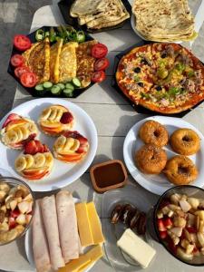 a table topped with plates of food and pizza at Djerba 7 in Aghīr +44 photos