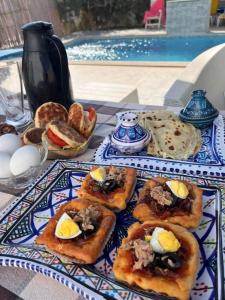 a table with a plate of food on a table at Djerba 7 in Aghīr