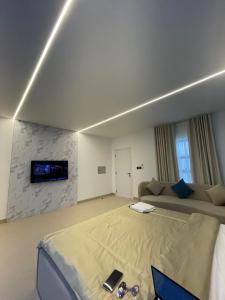 a bedroom with a bed and a tv on a wall at EK Homes in Ras al Khaimah