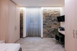 a room with a desk and a stone wall at 5 Terre Lodge in La Spezia