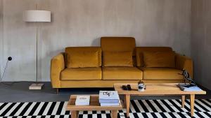 a yellow couch in a living room with a coffee table at hellofrom Tobacco Warehouse in Kavála +92 photos