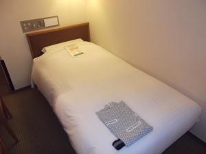 un posto letto in una camera d'albergo con un cartello sopra di Ichikawa Grand Hotel a Ichikawa