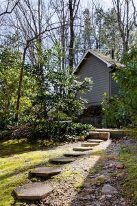 a garden with a path leading to a house at The Forest Door - Studio Suite in Stone Cottage in Tryon