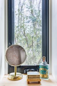a mirror sitting on a table next to a window at The Forest Door - Studio Suite in Stone Cottage in Tryon +17 photos