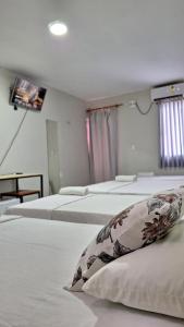 a room with three beds with a tv on the wall at Canto da Duna Hotel in Barreirinhas +6 photos