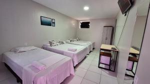 a hotel room with two beds and a sink at Canto da Duna Hotel in Barreirinhas