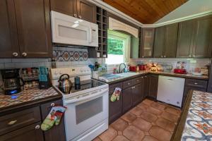 a kitchen with wooden cabinets and white appliances at Roscoe Cabin Pet friendly in Roscoe +36 photos