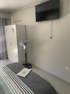 a room with a bed and a lamp and a refrigerator at Shady Seringa Accommodation in Vanderbijlpark