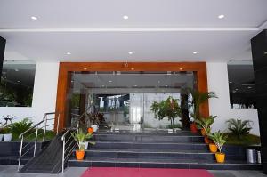 a lobby with stairs and plants in a building at Hotel Orcella in Tirupati