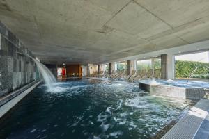 a swimming pool with a waterfall in a hotel room at Hotel Bonvino Badacsony in Badacsonytomaj
