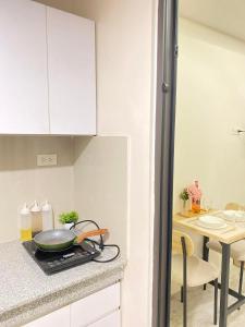 a kitchen with a counter with a frying pan on a stove at Thyme Residence The VAs Nest Near Anjo World Free Pool and Gym in Minglanilla