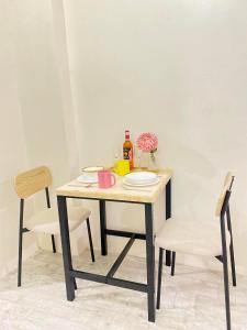 a table with plates and a bottle of wine on it at Thyme Residence The VAs Nest Near Anjo World Free Pool and Gym in Minglanilla