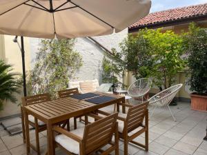 a wooden table and chairs with an umbrella on a patio at La dolce vita in Intra