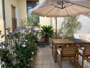 a patio with a table and umbrella and flowers at La dolce vita in Intra