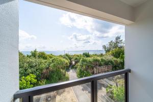 a balcony with a view of the ocean at LAGUNA OKINAWA Beachfront YAKA in Kin