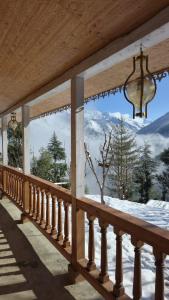 a balcony with a view of a snow covered mountain at The magic meadows in Kulu