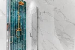 a bathroom with a shower with white marble at Sublime brand-new studio with air conditioning in Plaisance-du-Touch