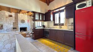 a kitchen with wooden cabinets and a red refrigerator at The Jasmine Hill in Aegenitissa +16 photos