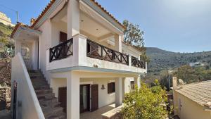 a white house with stairs and a balcony at The Jasmine Hill in Aegenitissa