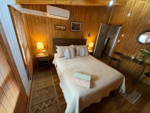 a bedroom with a large bed with two night stands at Hostal Senderos del Sur in Freire