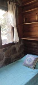 a bedroom with a bed with a window and a pillow at Habitaciones individuales o Dobles en La Llave in San Javier
