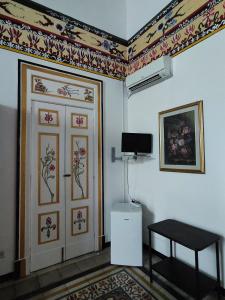 a room with a door and a tv on the wall at B&B Palazzo Antonelli in Monopoli