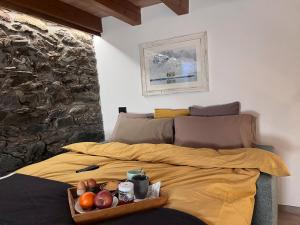 a bed with a tray of fruit on it at Little Wild House in Saint Vincent