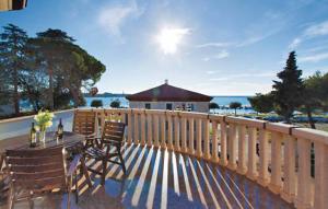 a deck with a table and chairs and a fence at Apartments Villa Teuta in Umag